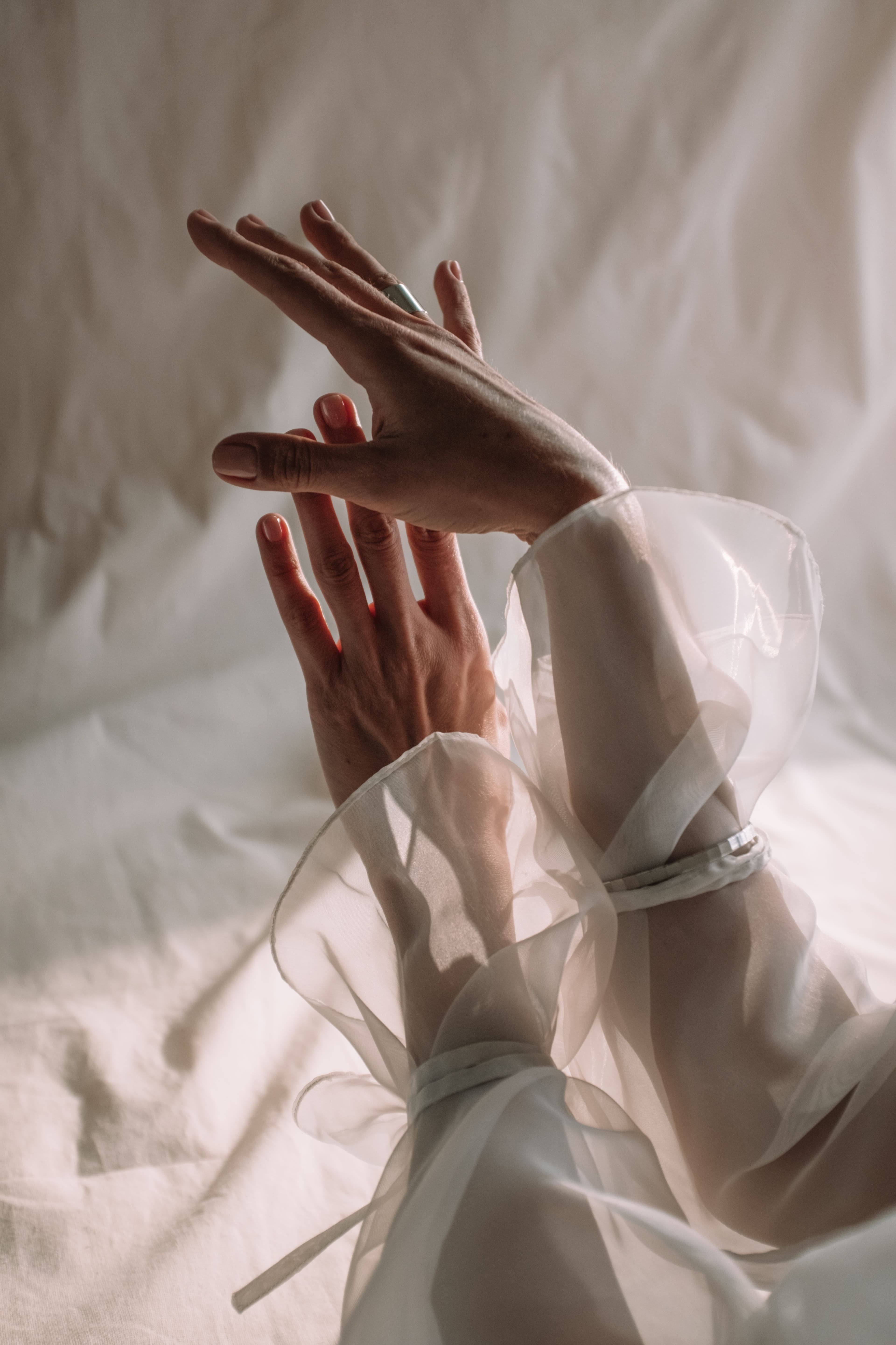Editorial hands in sheer ruffled sleeves